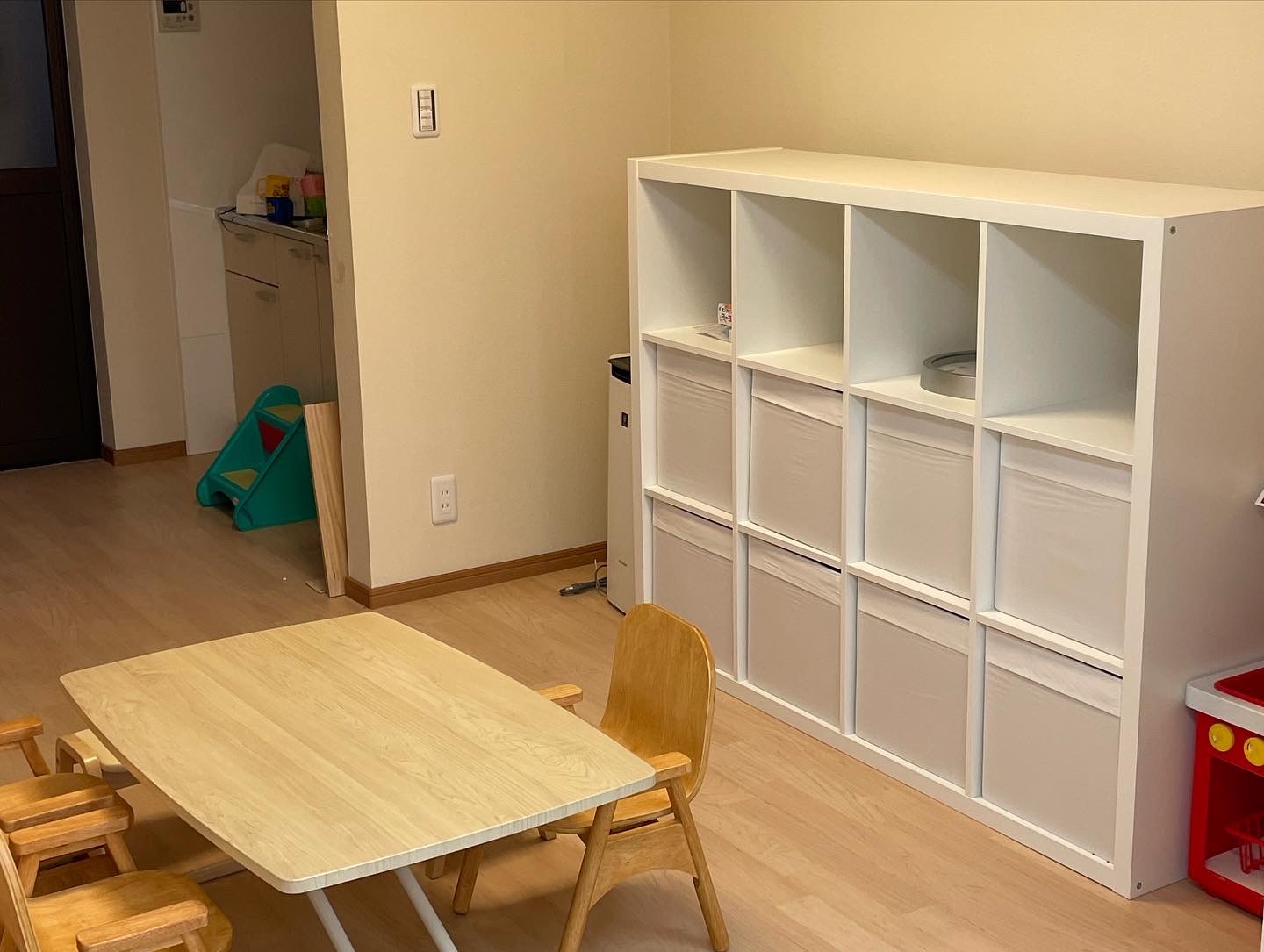 子ども用の机と椅子、収納棚のあるめばえの室内